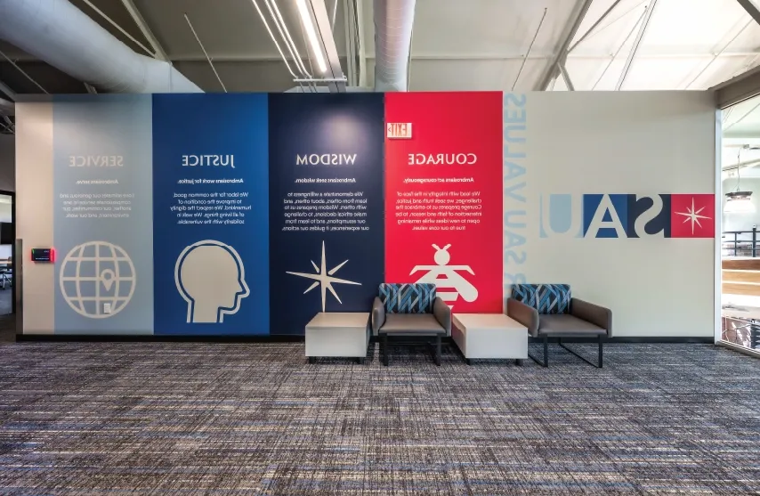 A wall in Higgins Hall with images representing SAU's values of courage, wisdom, justice and service.